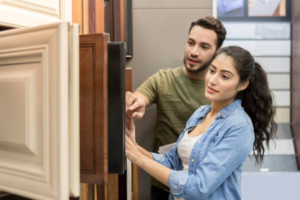 couple look at cabinet samples in hardware store - home decoration stock pictures, royalty-free photos & images