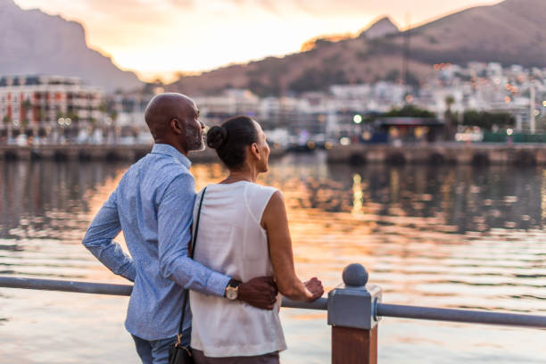 couple looking at sunset at cape town waterfront - travel stock-fotos und bilder