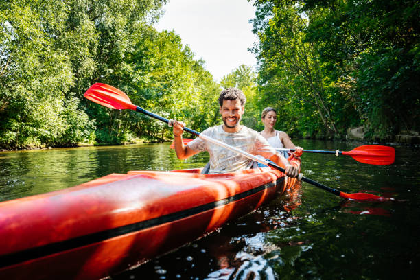 couple paddling together in kayak - travel stock pictures, royalty-free photos & images