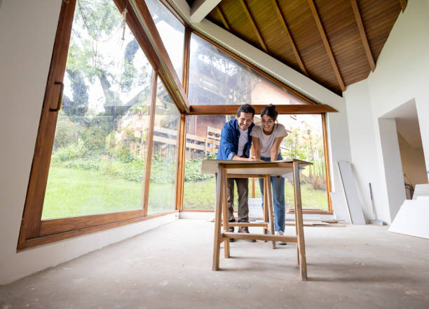 couple renovating their house and looking at the blueprints - home decoration stock pictures, royalty-free photos & images