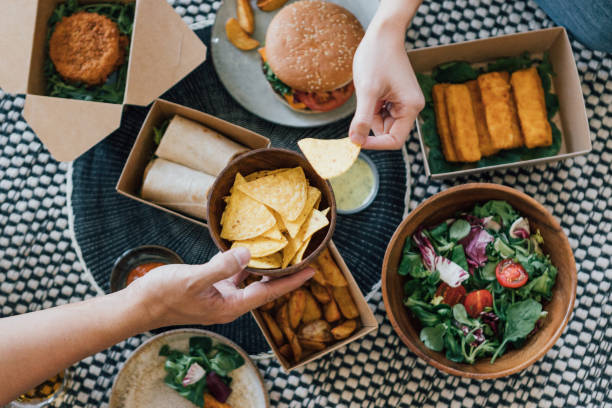 couple sharing takeaway food at home - junk food stock pictures, royalty-free photos & images
