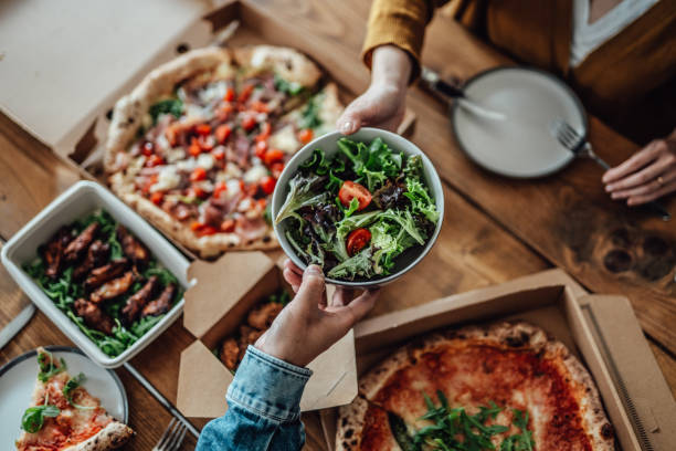 couple sharing takeaway meal at home - junk food stock pictures, royalty-free photos & images