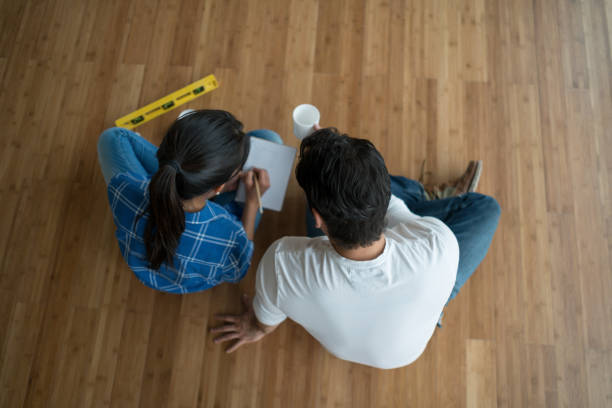 couple sitting at an empty room talking about interior design - home decoration stock pictures, royalty-free photos & images