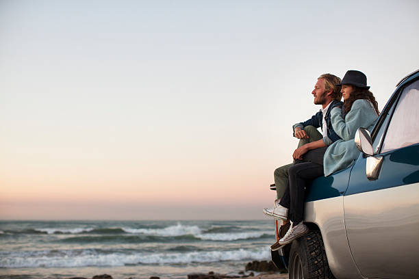 couple sitting on truck looking at ocean view - travel stock pictures, royalty-free photos & images