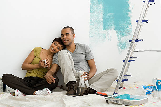 couple taking a break from painting - home decoration stock pictures, royalty-free photos & images