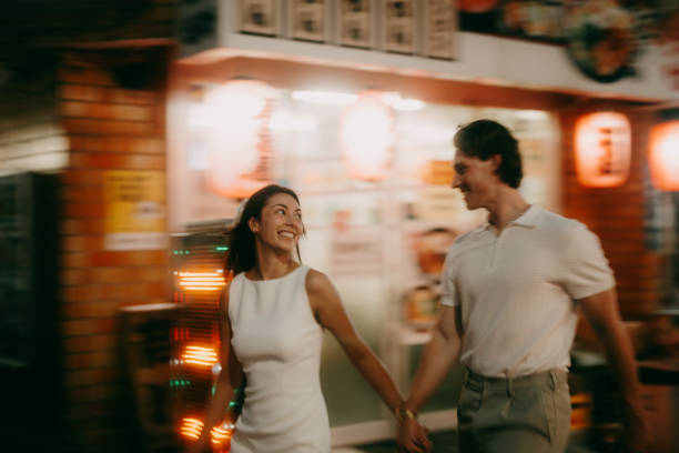 couple walking through tokyo backstreet alley with izakaya at night - travel stock pictures, royalty-free photos & images