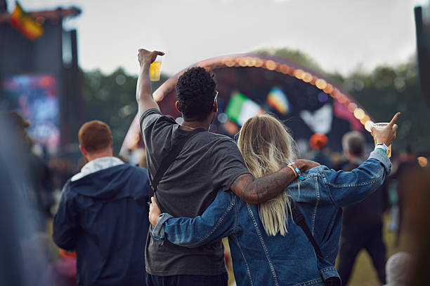 couple watching concert & holding beers, rear view - concert stock pictures, royalty-free photos & images