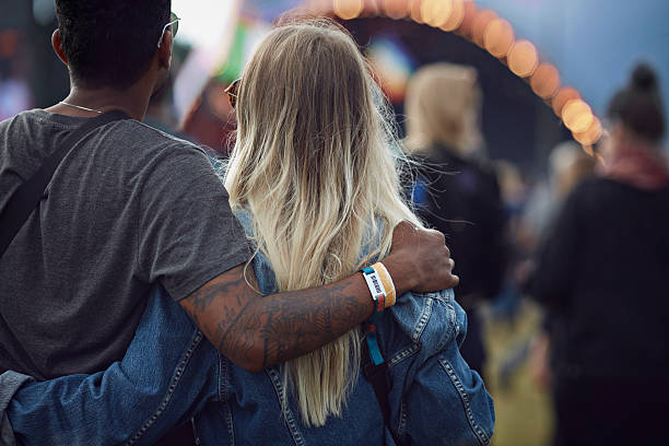 couple with arms around each other at concert - concert stock pictures, royalty-free photos & images