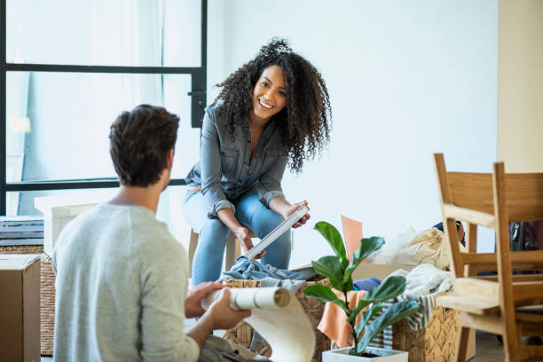 couples déballant des sacs et des boîtes dans le salon - garden decoration photos et images de collection