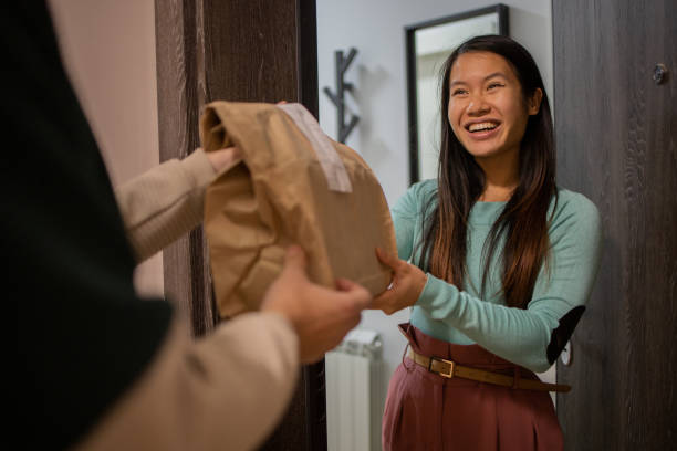 courier delivering fast food to the customer - junk food stock pictures, royalty-free photos & images