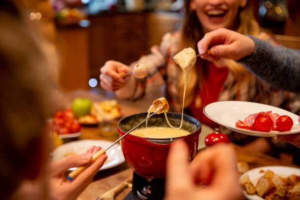 coworkers eating fondue - food stock pictures, royalty-free photos & images