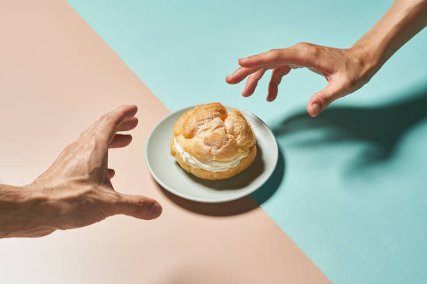 cream puff and hands on a colorful background. - food stock pictures, royalty-free photos & images