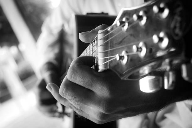 cropped hands of a man playing an acoustic guitar - concert stock pictures, royalty-free photos & images