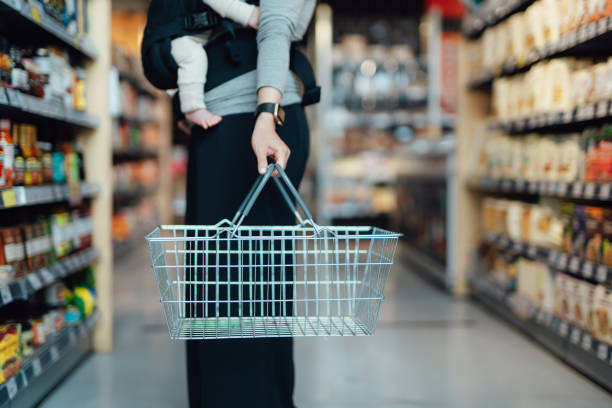 cropped shot of mother carrying a shopping cart, doing grocery shopping in supermarket - food fotografías e imágenes de stock