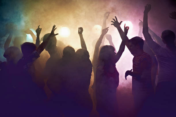 crowd of people at concert waving arms in the air - concert stock pictures, royalty-free photos & images