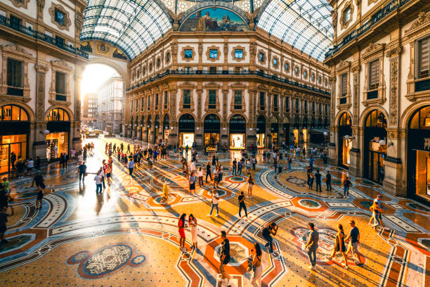 crowd of people in galleria vittorio emanuele ii at sunset, milan, italy - travel stock pictures, royalty-free photos & images