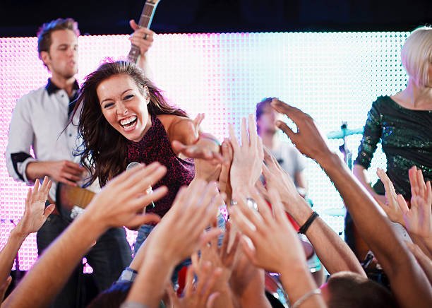 crowd reaching toward female singer on stage - concert stock pictures, royalty-free photos & images