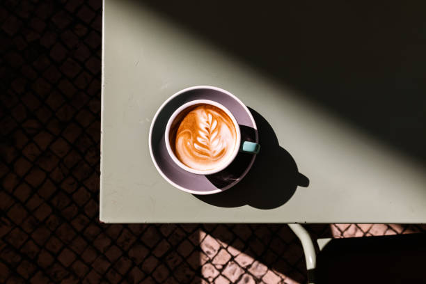 cup of cappuccino with latte art on the table, directly above view - coffee stockfoto's en -beelden