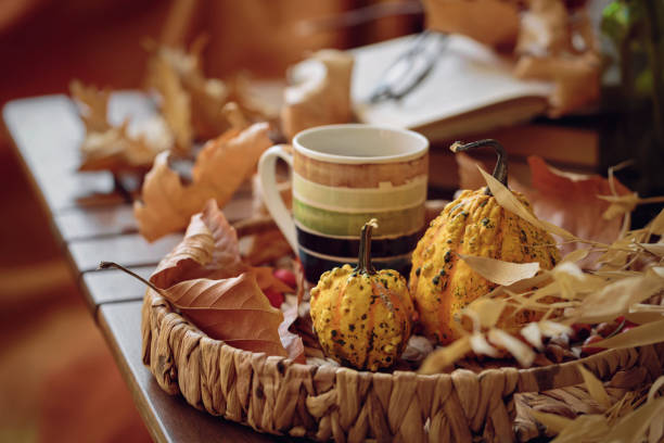 cup of coffee on wooden table with pumpkins, books and dried leaves outdoor - home decoration stock pictures, royalty-free photos & images