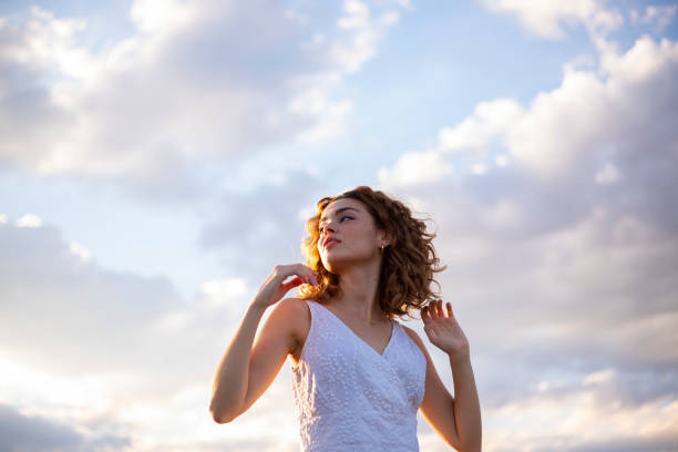 curly hair woman outdoors sky background - fashion stock pictures, royalty-free photos & images