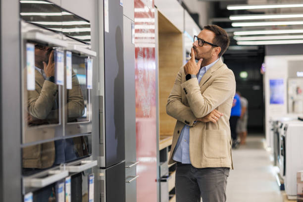 customer checking refrigerators in an appliance store - home decoration stock pictures, royalty-free photos & images
