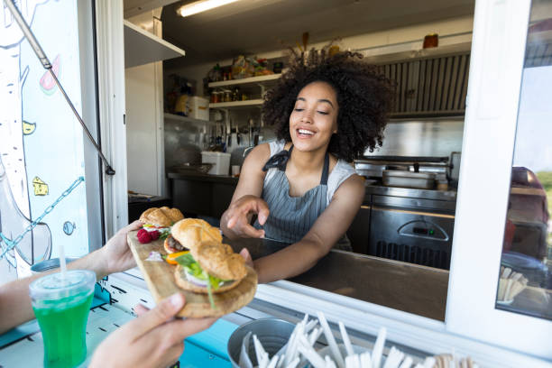 customer taking burgers from food van - junk food stock pictures, royalty-free photos & images