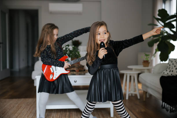 cute girls playing guitar and singing - concert stock pictures, royalty-free photos & images