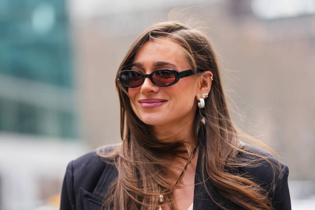 Danielle Bernstein wears black sunglasses, silver earrings, black necklace silver pendant, black oversized blazer jacket, outside La Pointe, during...