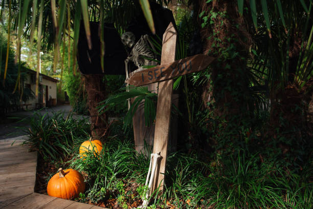 decor in the park for halloween. halloween street decor. graves, headstones, skeletons and crosses. happy halloween. feast of the dead. - garden decoration stockfoto's en -beelden