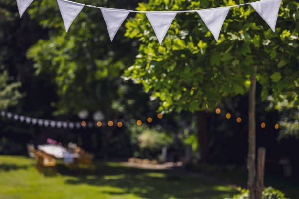 decorated garden with set table, flag garland and paper lanterns. garden party, summer festival, birthday party, baptism or wedding. - garden decoration stock pictures, royalty-free photos & images