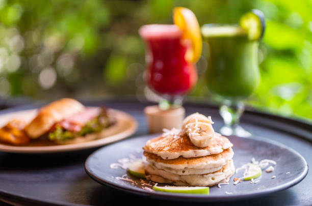 delicious breakfast with croissants, pancakes and two fresh fruit juices - garden decoration stock pictures, royalty-free photos & images