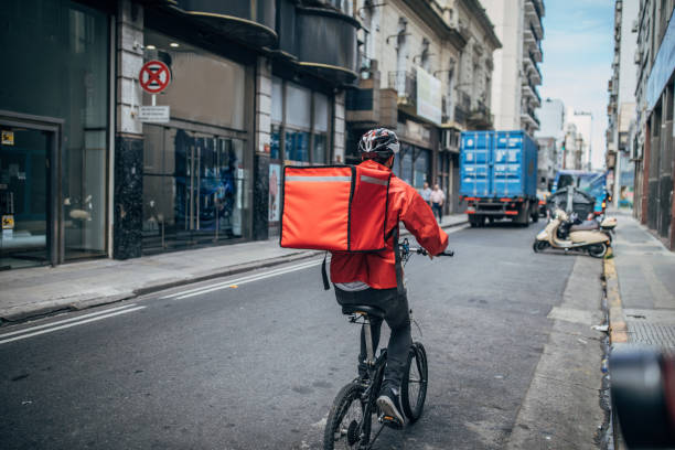 delivery boy on bicycle in city - food stock pictures, royalty-free photos & images