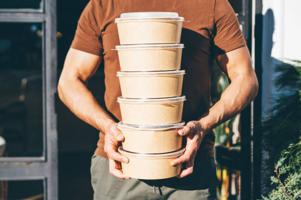 delivery man picking up take away food order. - junk food stock pictures, royalty-free photos & images