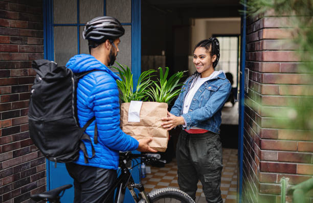delivery man with bicycle delivering potted plants outdoors in city, coronavirus concept. - food stock pictures, royalty-free photos & images
