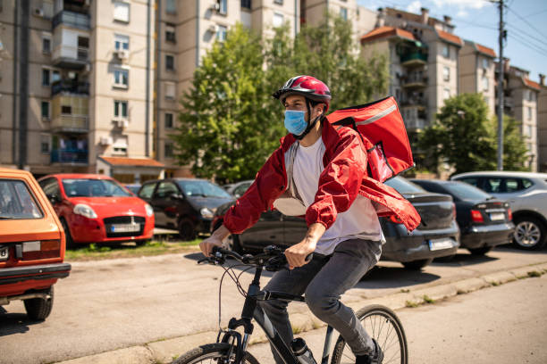 delivery man working during coronavirus pandemic - junk food stock pictures, royalty-free photos & images