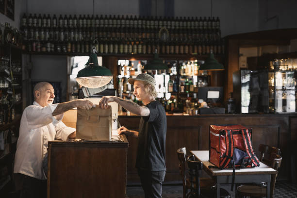 delivery person receiving order in a restaurant - junk food stock pictures, royalty-free photos & images