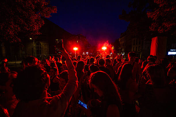 Dense crowd bathes in red stage lights at night during an open-air concert for the Fete de la Musique in Clermont-Ferrand France on June 21 2025.