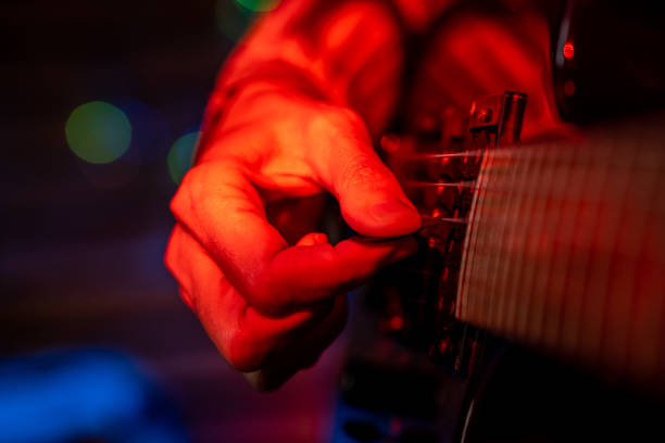 detail of a woman's hand playing an electric guitar. - concert stock pictures, royalty-free photos & images