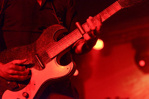 detail of man playing guitar on stage with a silde - concert stock pictures, royalty-free photos & images