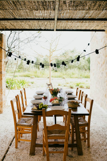 dining table with chairs and plates arranged at patio in backyard - garden decoration stock pictures, royalty-free photos & images