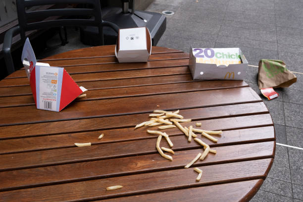 Discarded chips and McDonalds packaging lie on the ground and on a cafe table in central London, on 26th September 2021, in London, England.