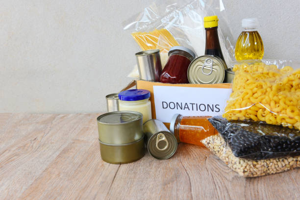 donations box with canned food on wooden table background pasta canned goods and dry food non perishable with pea cooking oil rice noodles spaghetti macaroni donations food,romania - food stock pictures, royalty-free photos &