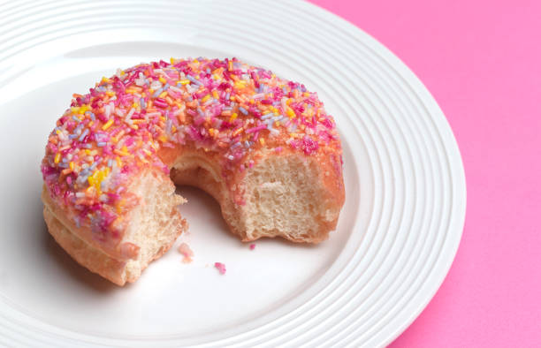 donut with missing bite - junk food stock pictures, royalty-free photos & images