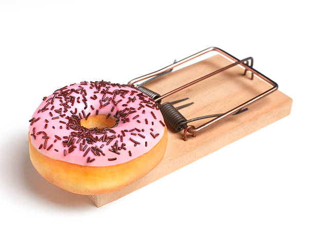 doughnut in mouse trap - junk food stock pictures, royalty-free photos & images