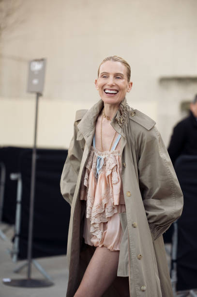 Dree Hemingway wears light peach colour mini shorts and top, long beige trench coat, and white bag outside the Chloe fashion show during the...