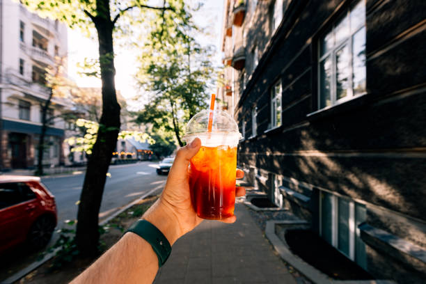 drinking iced coffee on a sunny summer day, personal perspective view - junk food stock pictures, royalty-free photos & images