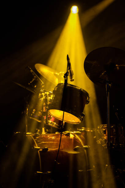 drum set on stage under a yellow light - concert stock pictures, royalty-free photos & images