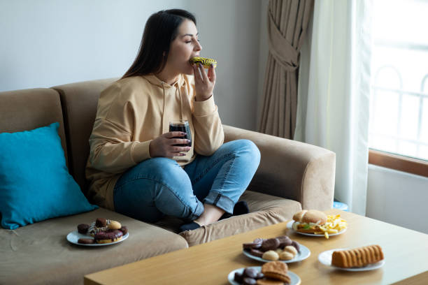 eating sugary food on sofa - food stock pictures, royalty-free photos & images