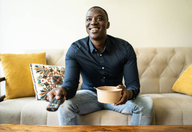 eating take-out and watching tv at home - junk food stock pictures, royalty-free photos & images
