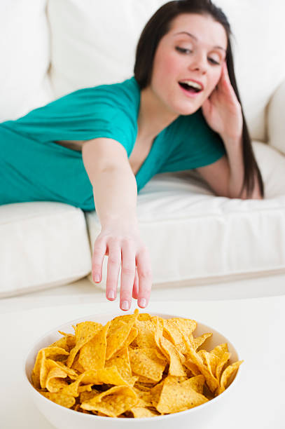 eating tortilla chips - junk food stock-fotos und bilder